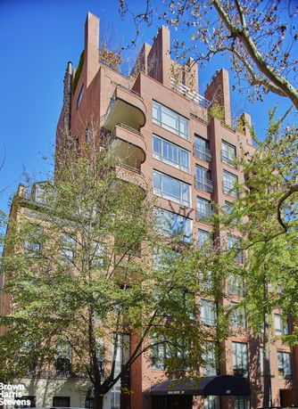 Front view of a multi-story brick building with balconies and windows.