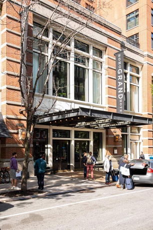 Front view of a multi-story hotel building with large windows and a covered entrance.