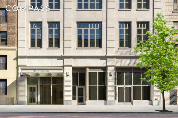 Front view of a multi-story building with large windows and a glass entrance.