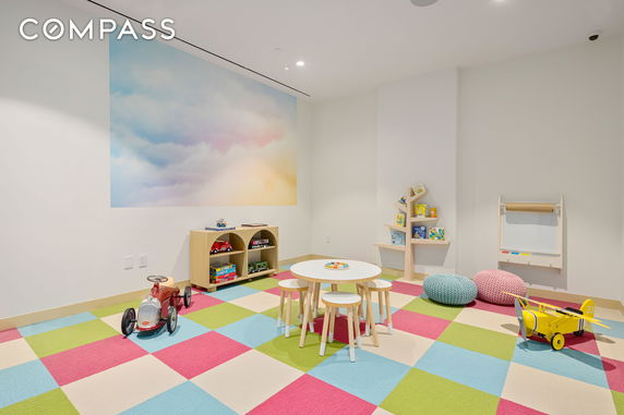 Colorful indoor play area with toys, small table, and stools.