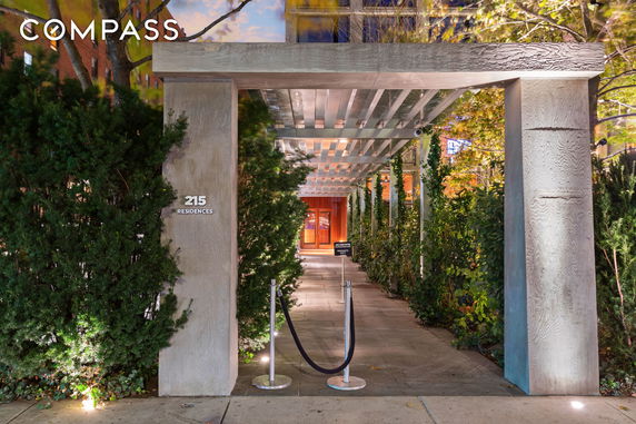 Front view of a residential entrance with a pathway and modern pergola structure.