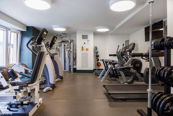 Indoor gym area with various exercise machines and equipment.