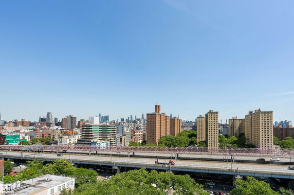 Panoramic view of urban skyline with multiple high-rise buildings and highways.