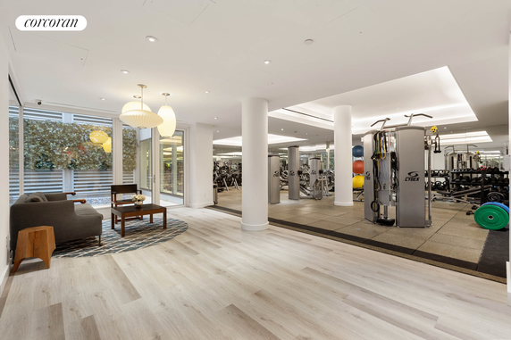 Interior view of a gym with exercise equipment and a seating area.