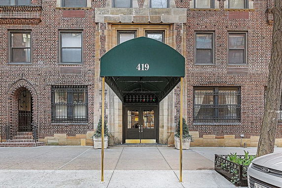 Front view of a brick building with a green canopy entrance.