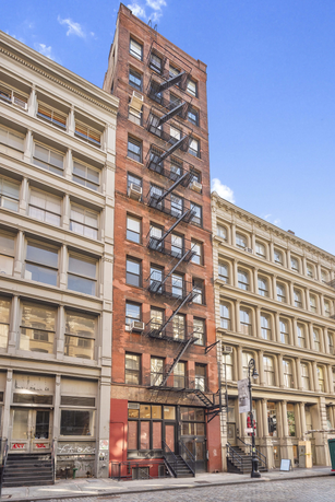 Front view of a multi-story brick building with external fire escape staircases.