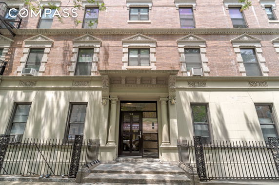 Front view of a multi-story brick building with detailed stonework around windows and entrance.