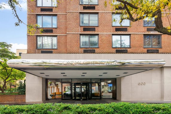 Front view of a building entrance with a modern design and brick exterior.