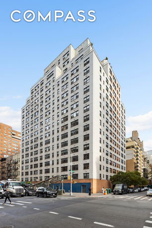 Front view of a multi-story apartment building on a street corner.
