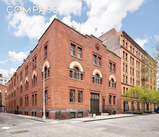 Front view of a historic brick building on a corner street.