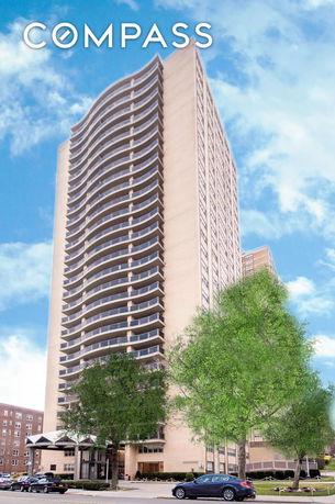 Front view of a tall residential building with multiple balconies.