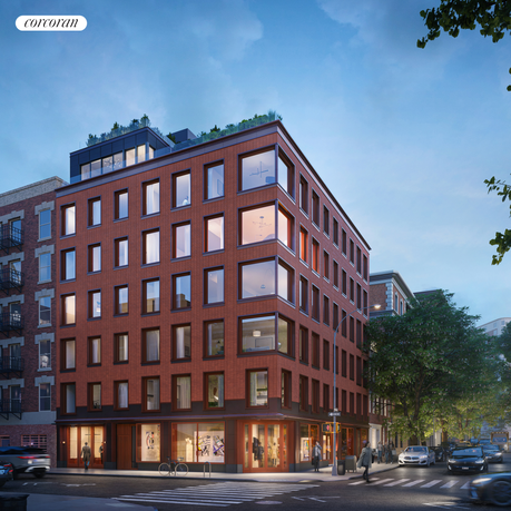 Front view of a multi-story brick building on a city street corner.