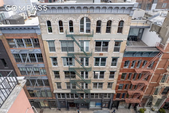 Front view of a multi-story building with fire escapes.