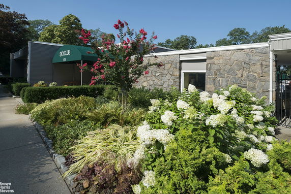 Front view of building with stone facade and green awning labeled 'Sky Club'.