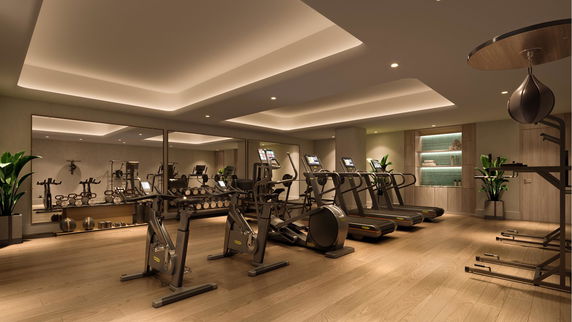 Interior view of a gym with exercise equipment and mirrors.