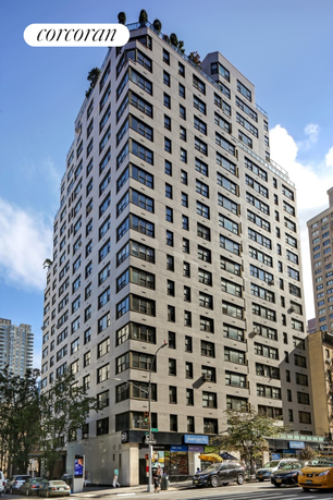 Front view of a multi-story apartment building with commercial stores at street level.
