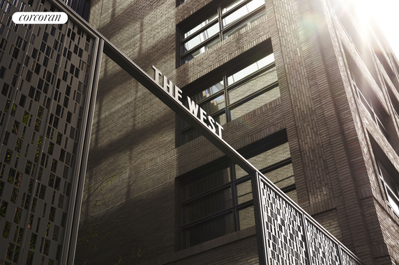 Front view of a modern multi-story building with brick facade and large windows.