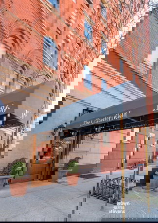 Front view of a multi-story building with brick facade and arched windows. Awnings with 'The Chesterfield' and '186' written on them are visible over the entrance.