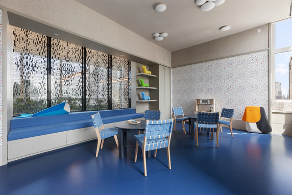 Indoor play area with chairs, tables, and playful decorations.