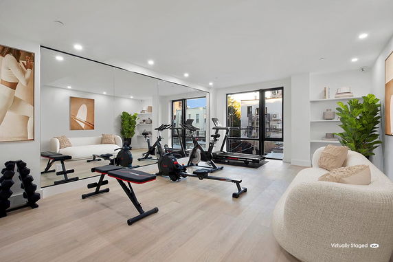 Interior view of a room with gym equipment and seating area.