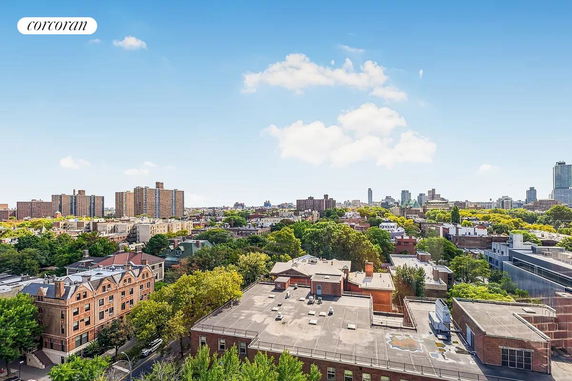 Panoramic view of a cityscape with buildings and greenery under a blue sky.