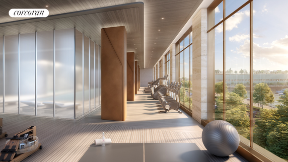 Modern gym area with exercise equipment and large windows.