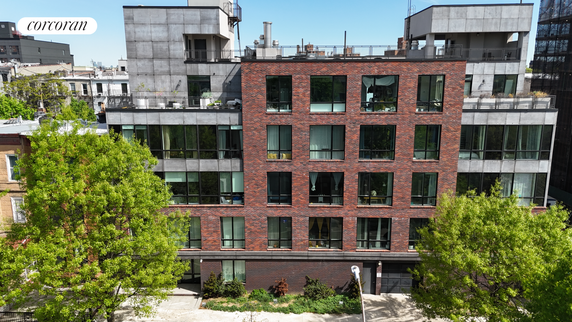 Front view of a multi-story building with brick facade and large windows.