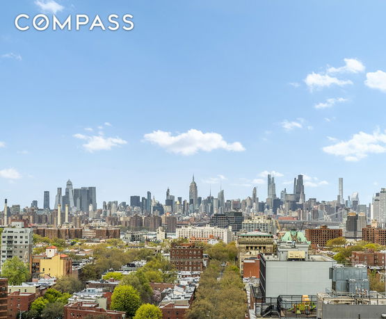 Panoramic view of a cityscape with skyscrapers and buildings under a blue sky.