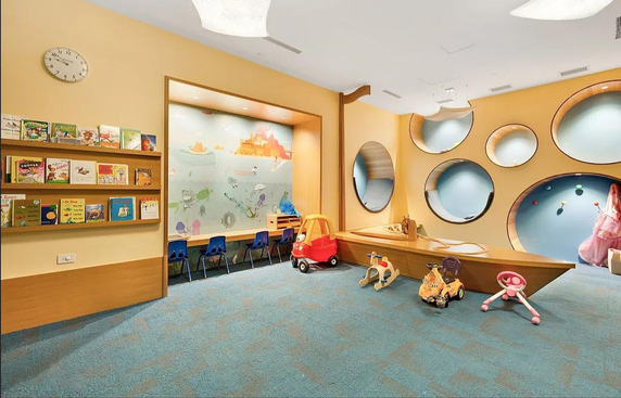 Indoor children's play area with toys and bookshelves.