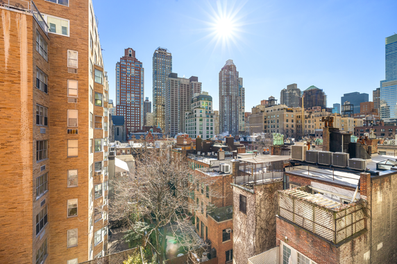 City skyline view with multiple tall buildings under a clear blue sky.