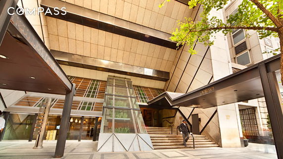 Front view of a modern building with a glass and metal canopy entrance.