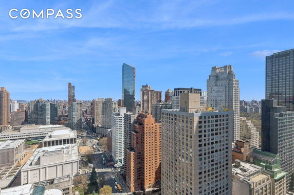 Panoramic view of a cityscape with tall buildings and clear blue sky.