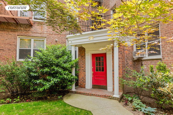 Front view of a building with a red door and brick exterior.