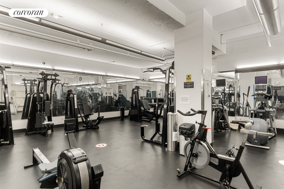 Interior view of a gym with various exercise equipment and mirrors.