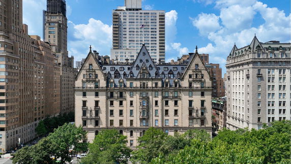 Front view of a historic multi-story building with ornate architectural details and pointed roof structures.