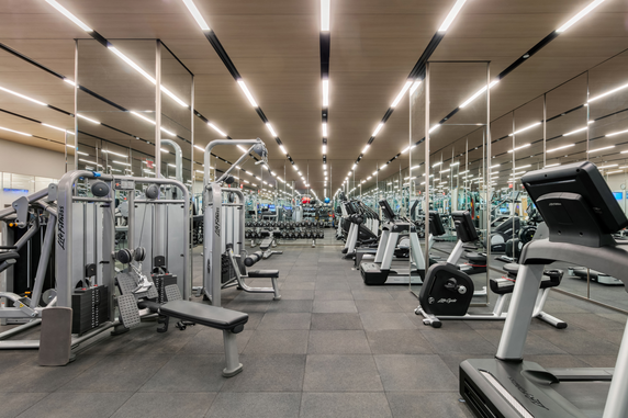 Indoor gym area with exercise equipment and mirrors.
