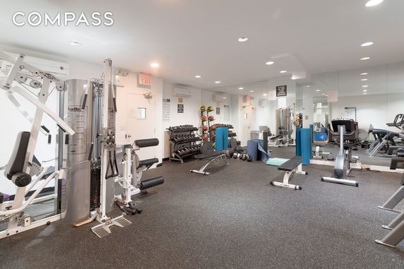 Interior view of a gym with various exercise equipment and weights.