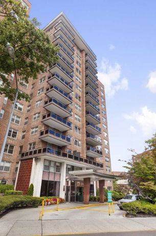 Front view of a high-rise apartment building with balconies.