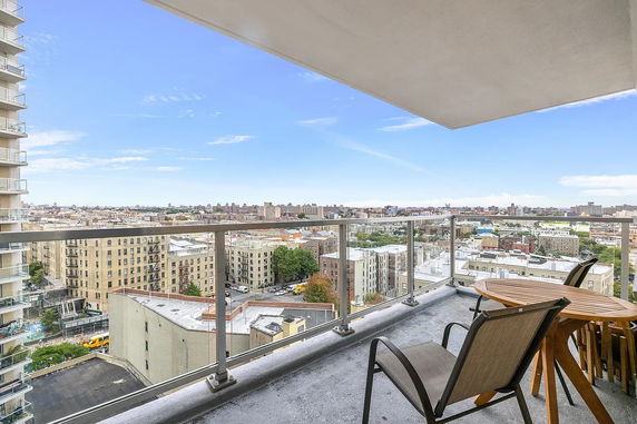 View from a balcony overlooking residential buildings and cityscape.