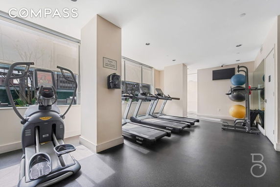 Indoor gym area with exercise equipment and large windows.