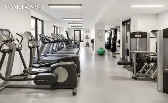 Indoor gym area with exercise machines and fitness equipment.