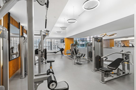 Gym area with modern exercise equipment and large windows.