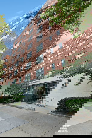 Front view of a multi-story brick building with stair entrance.