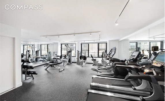 Indoor fitness area with exercise machines and large mirrors.