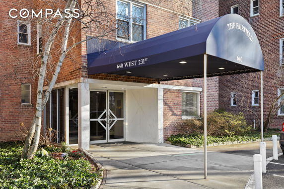 Front view of a brick apartment building with a covered entrance.