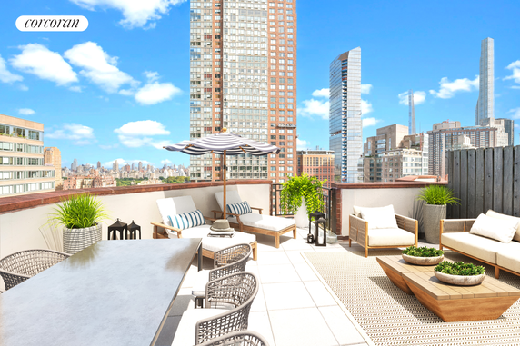 Rooftop patio with seating area and city skyline in the background.