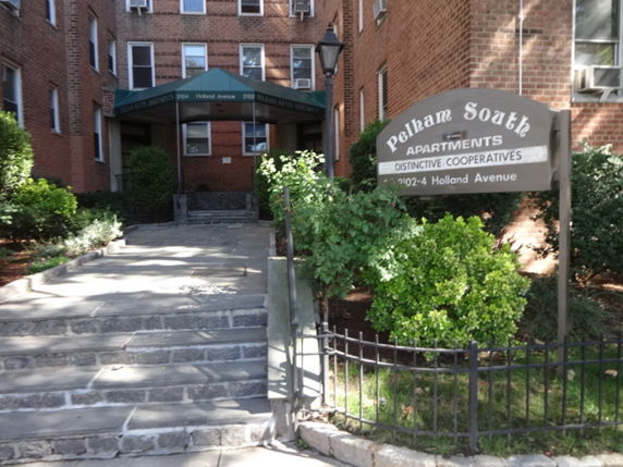 Front view of a multi-story brick apartment building entrance.