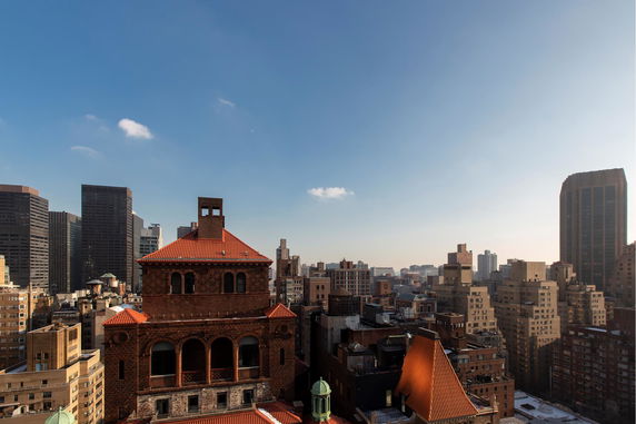 Panoramic view of a cityscape with various high-rise buildings and a clear sky.