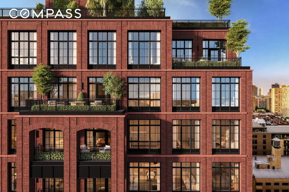 Front view of a brick multi-story building with large windows and balconies.