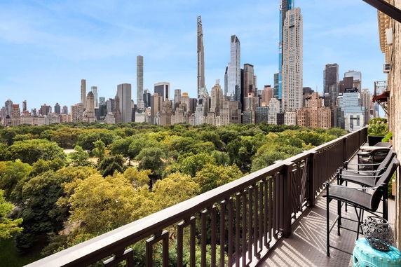 Panoramic view from a balcony overlooking a city skyline and park.